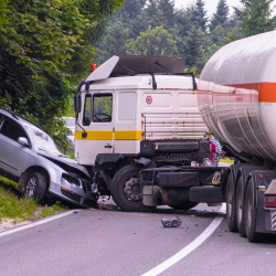 Damaged tanker truck and car after a head-on collision