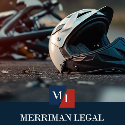 Scene of a motorcycle accident, with a damaged helmet and motorcycle lying on the ground
