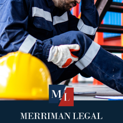 Construction worker sitting on ground while holding injured leg