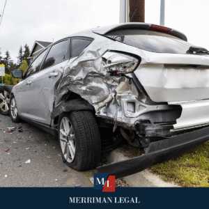 Vehicle with severe rear quarter panel damage after a side collision near a roadside curb.